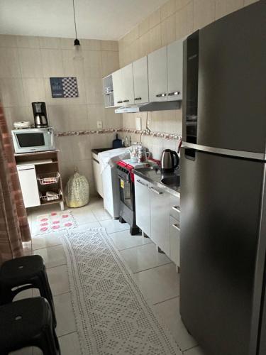 伊塔佩马Residencial Lara的厨房配有不锈钢冰箱和白色橱柜