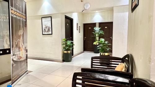 卡拉奇Royal Inn Hotel的建筑里带椅子和植物的走廊