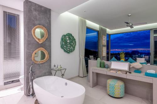 卡塔海滩Villa Omari 5Bedroom with pool的一间带白色浴缸和大窗户的浴室