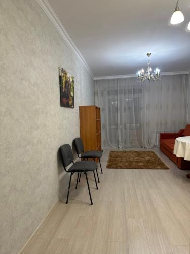 Prigorodnyyоднокомнатная квартира的客厅配有两把椅子和一张床