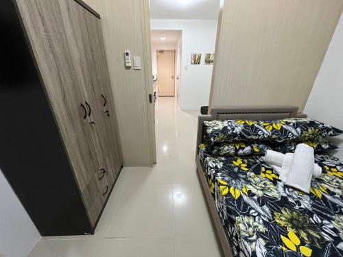 马尼拉Staycation Sea Residences MOA Jermel的一间卧室配有一张黑色和黄色毯子的床