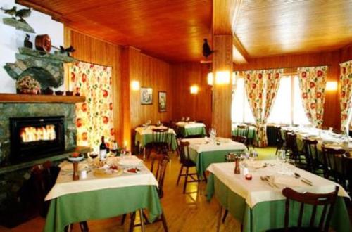 尚波吕克康帕尼欧酒店的一间带桌椅和壁炉的餐厅