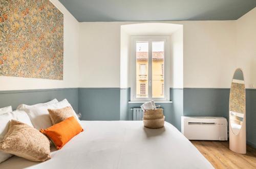 米兰Ripa Apartments Milano - Vigevano的卧室设有一张白色大床和一扇窗户。