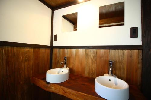 奥多摩町きよかわゲストハウス的木墙上带两个水槽的浴室