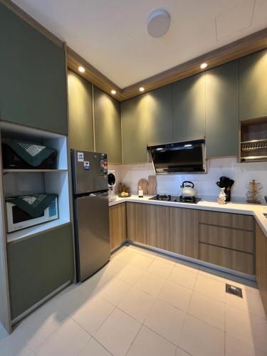 芙蓉Al Mansor Islamic Guestroom的厨房配有绿色橱柜和冰箱。
