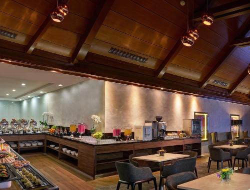 雪邦萨玛萨玛KLIA快捷酒店（空侧中转酒店） 的一间带桌椅和柜台的餐厅