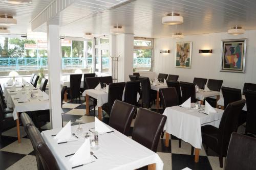科隆弗赖海特酒店的用餐室配有白色桌子和黑色椅子