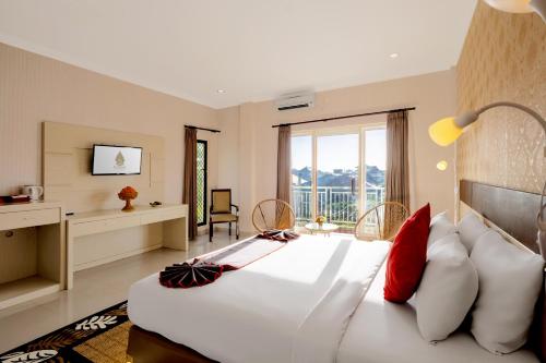 库塔The Kanjeng Hotel Kuta的卧室配有带红色枕头的大型白色床
