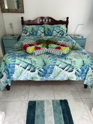安塞罗亚莱Royal Bay Apartment的一间卧室配有一张带蓝色和绿色棉被的床