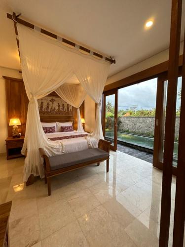 乌布Gyanesh Villa的一间卧室设有一张带大窗户的天蓬床