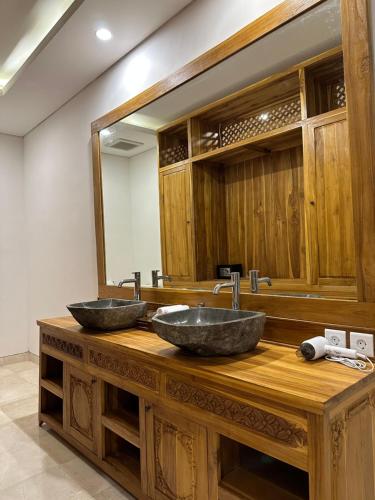 乌布Gyanesh Villa的木台上两个水槽,配有镜子