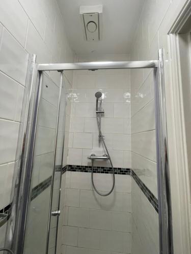 米尔顿凯恩斯Abbey Guest House的带淋浴的浴室,带玻璃门