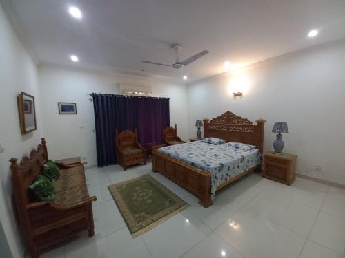 伊斯兰堡DHA 2 Villa, Near Giga Mall, Islamabad的一间卧室,卧室内配有一张床和椅子