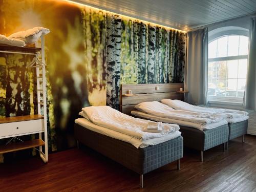 劳马Hotel Sleep at Rauma的带三张床和窗户的客房