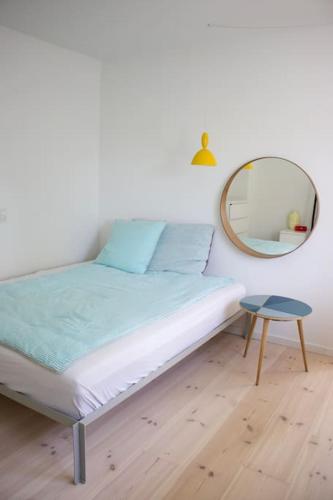 哥本哈根House in beautiful Copenhagen的一间卧室配有一张带镜子和凳子的床