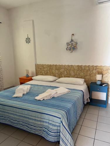 兰佩杜萨Residence La Conchiglia的一间卧室配有带毛巾的床