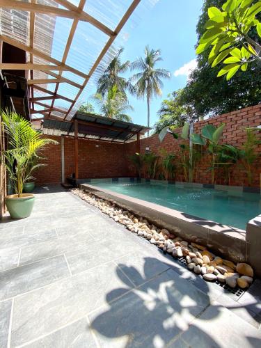 HumaKutum's Wooden House - Private Pool, Breakfast & Cafe的一座带砖砌建筑的后院游泳池