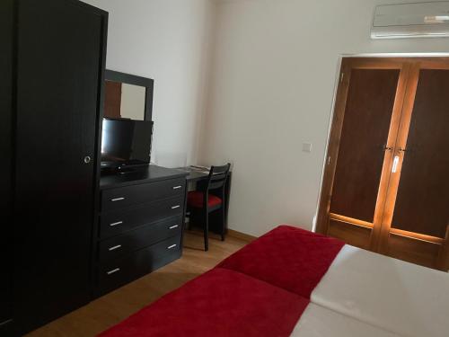 托里迪蒙科尔武卡萨多台拉图鲁酒店的一间卧室配有一张床和一个带电视的梳妆台