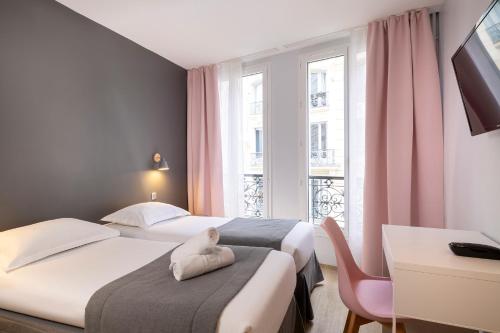 巴黎勒杰德尔酒店的酒店客房设有两张床、一张书桌和一个窗户。