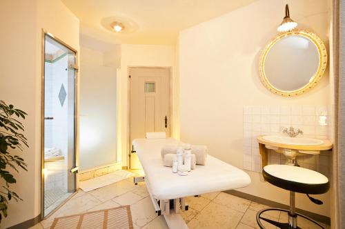 瓦尔道拉Mirabell Dolomites Hotel Luxury Ayurveda & Spa的白色的浴室设有水槽和镜子