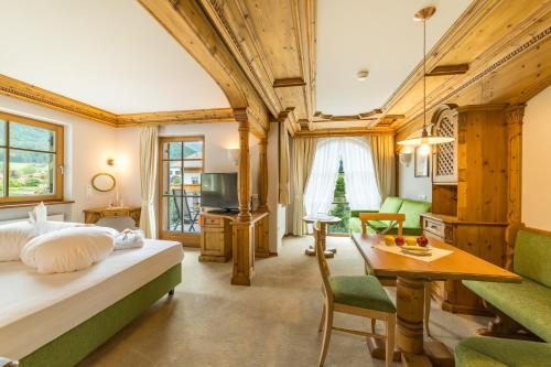 瓦尔道拉Mirabell Dolomites Hotel Luxury Ayurveda & Spa的一间卧室设有一张床和一间客厅。