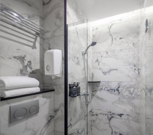 新加坡Hotel Mi Rochor的带淋浴的浴室和玻璃门