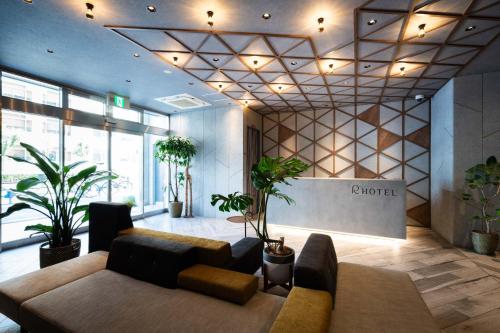 大阪R Hotel Namba South的大厅,在大楼里配有沙发和盆栽植物