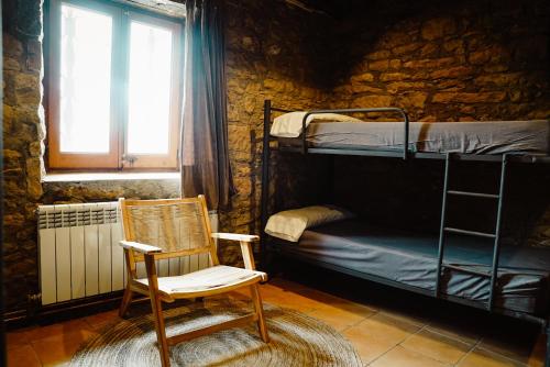 NavésCases Altes de Posada的配有双层床的客房内的摇椅