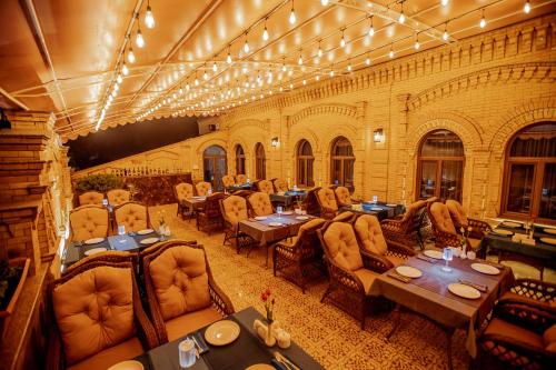 撒马尔罕HOTEL SILK ROAD EMPIRE SAMARKAND的一间在房间内配有桌椅的餐厅