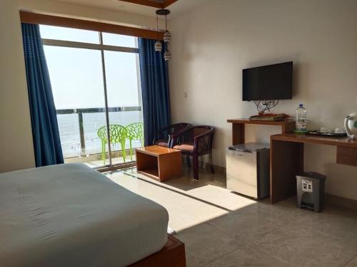 库克斯巴扎Hotel Sea Moon的一间卧室设有一张床、一台电视和一个窗口。