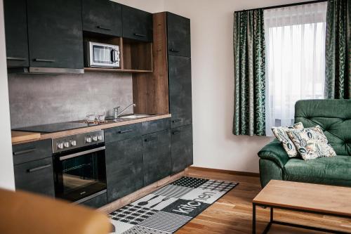 上陶恩Alpenhotel & Aparthotel Lanz的客厅设有厨房和沙发。