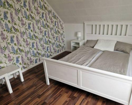 LillhärdalFerienhaus am Waldrand的卧室配有白色床和花卉壁纸