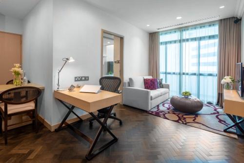 新加坡Fraser Suites Singapore的客厅配有书桌和沙发。