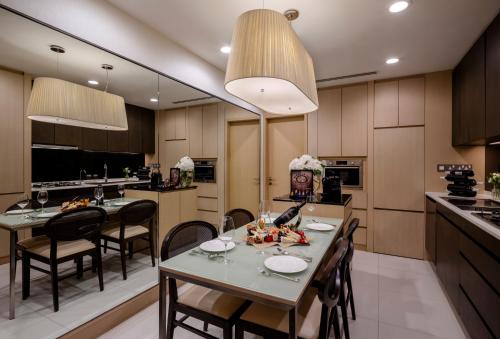 新加坡Fraser Suites Singapore的厨房以及带桌椅的用餐室。
