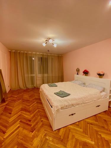 克拉科夫Cheap entire apartment in a super location的卧室配有白色的床,铺有木地板