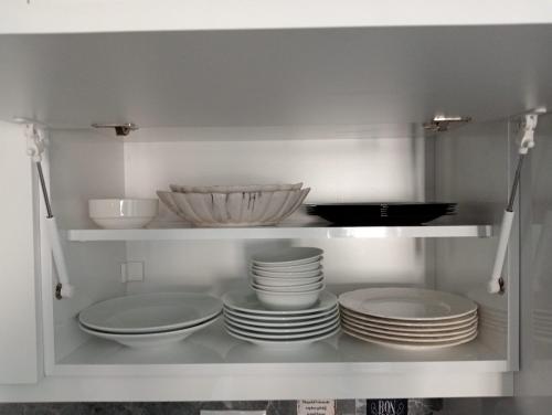 帕莫卡莱PRETTY HOUSE的装满盘子和碗的白色橱柜
