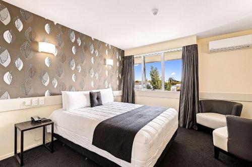基督城Hotel Elms Christchurch, Ascend Hotel Collection的卧室配有床、椅子和窗户。
