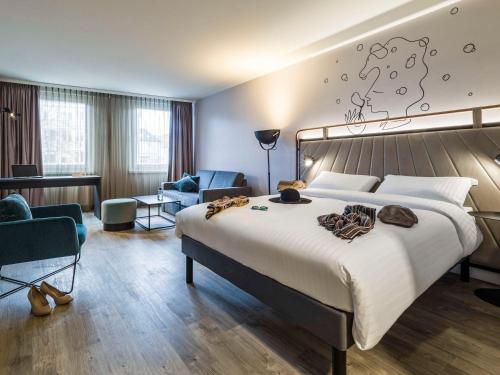 比勒费尔德ibis Styles Bielefeld City的酒店客房设有一张大床和一张书桌。