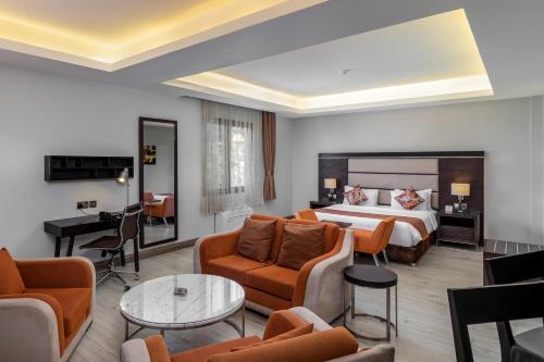 坎帕拉Best Western Plus The Athena Hotel Kampala的酒店客房设有床和客厅。