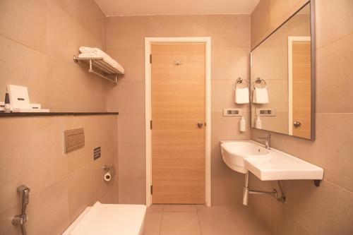 钦奈Hotel Star City的一间带水槽、卫生间和镜子的浴室