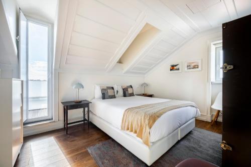 里斯本希亚多特林达德公寓 | 里斯本最佳公寓的白色的卧室设有床和窗户