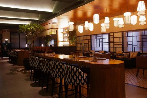钦奈Hotel Star City的餐厅设有木桌、椅子和吊灯。