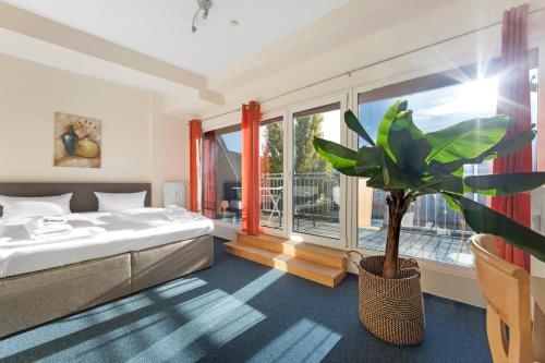 柏林康米纽斯酒店的一间卧室配有一张床和盆栽植物
