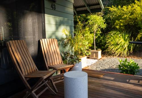 袋鼠谷Mike's Kangaroo Valley的两把木椅坐在种植了植物的门廊上