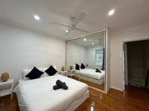 悉尼2 Bedroom Darling Harbour - Pyrmont 2 E-Bikes Included的一间白色卧室,配有两张床和镜子