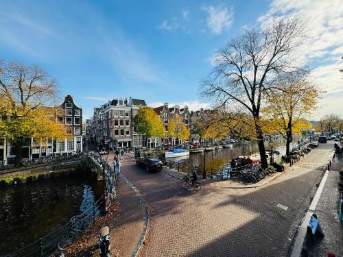 阿姆斯特丹装饰运河住宿加早餐旅馆的一条有河流、建筑和树木的城市街道