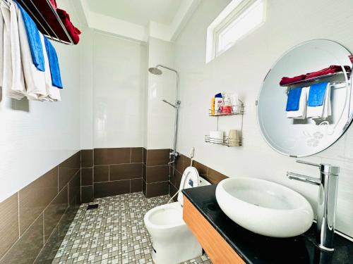 会安柯波恩海滨住宿加早餐旅馆的一间带水槽、镜子和卫生间的浴室