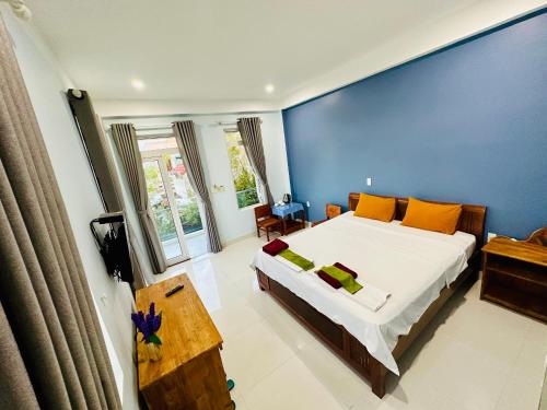 会安柯波恩海滨住宿加早餐旅馆的一间卧室设有一张大床和蓝色的墙壁