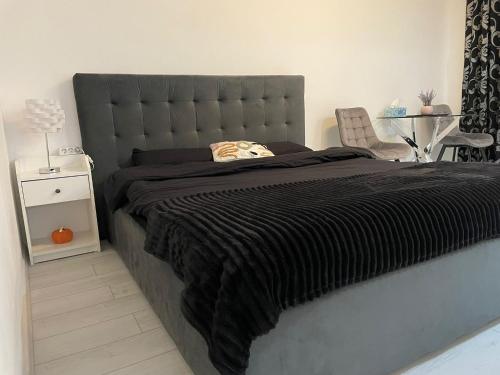布加勒斯特Fancy Studio Arena Nationala的一张带黑色毯子的床和一把椅子