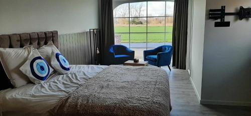 鲁瑟拉勒Rêveries的一间卧室配有一张床和两张蓝色椅子